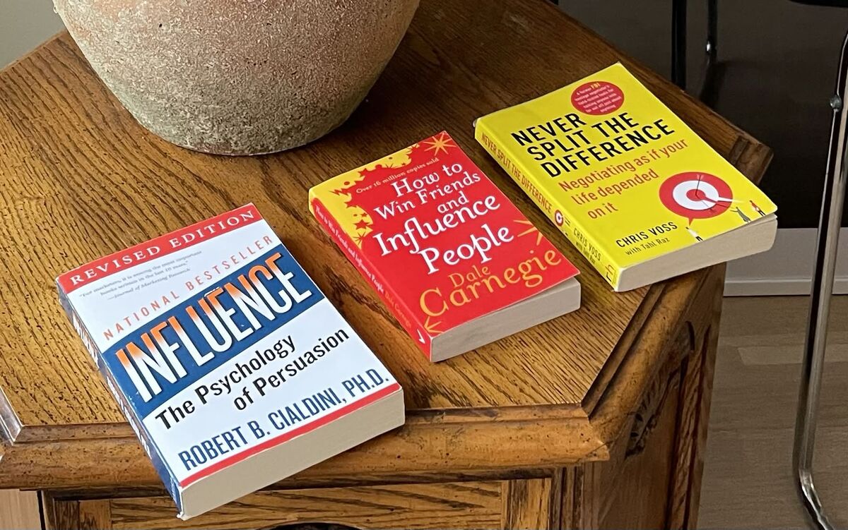 Influence by Robert Cialdini, How to Win Friends and Influence People by Dale Carnegie, and Never Split the Difference by Chris Voss